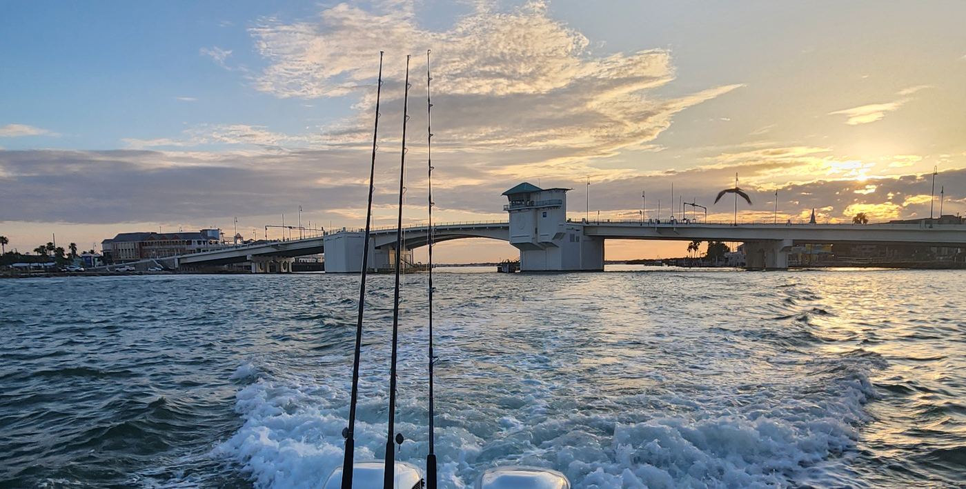 Rods and wake behind the boat, the bridge at sunrise